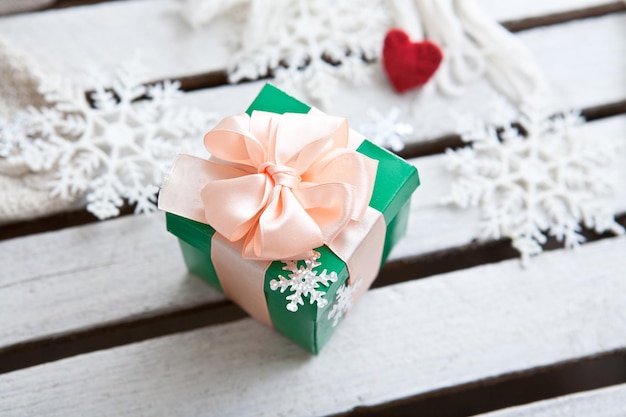 Weihnachtshölzerner weißer Hintergrund mit Geschenkbox und Schneeflocke Vektorillustration