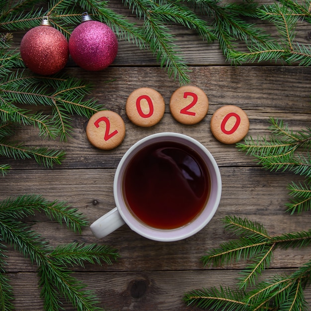 Weihnachtsholztisch mit Teebecher, Plätzchen für 2020 neues Jahr