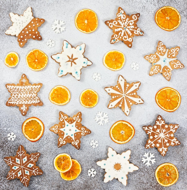 Weihnachtsingwerkekse in Form von Schneeflocken und getrockneter Orange