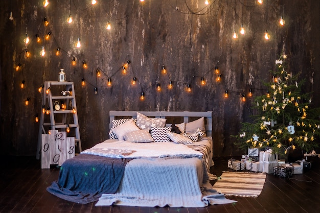 Weihnachtsinnenraum in dunkler Farbe mit Bett und Girlanden