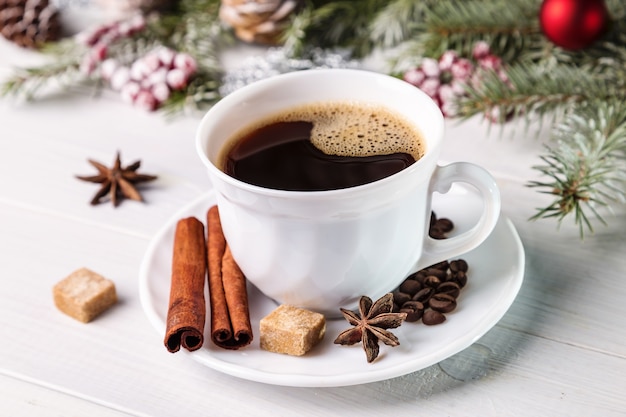 Weihnachtskaffee mit Fichtenzweigen und Zimtstangen