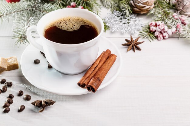 Weihnachtskaffee mit Fichtenzweigen und Zimtstangen