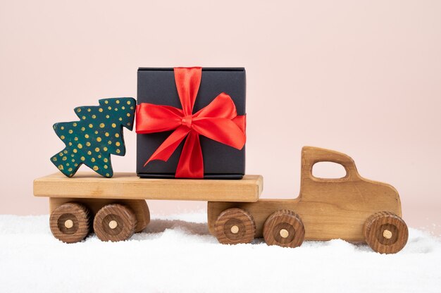 Weihnachtskarte. Holzspielzeug-LKW mit Weihnachtsschmuck. Urlaubskonzept. Foto in hoher Qualität