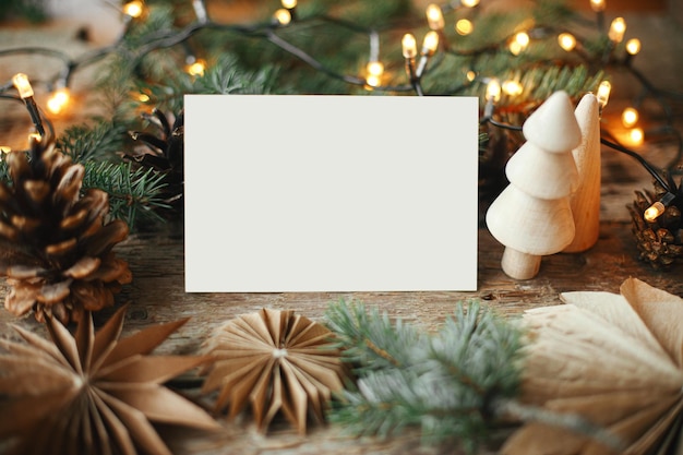 Weihnachtskarte mock up Leeres Grußkartenpapier Sterne Baumkegel Lichter auf rustikalem Holz