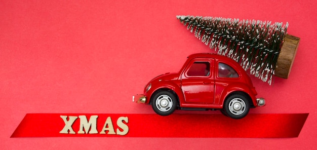 Weihnachtskarte rotes Spielzeugauto mit einem Weihnachtsbaum, der den Streifen hinuntergeht, steht das Wort geschrieben