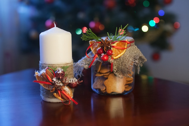 Weihnachtskerze und ok ookies in einem Glas. Weihnachtsstechpalme. Festliche Einrichtung