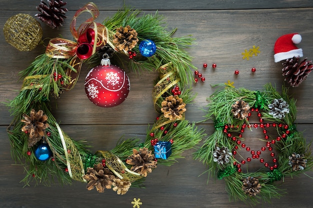 Weihnachtskiefer mit Zapfen, Bändern und goldenen Nüssen auf einem Holztisch