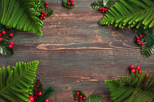 Weihnachtskiefernblatt und Mistel auf Holztisch, rot