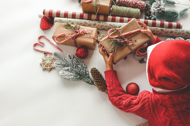 Foto weihnachtskind mit einem weihnachtsgeschenk in den händen