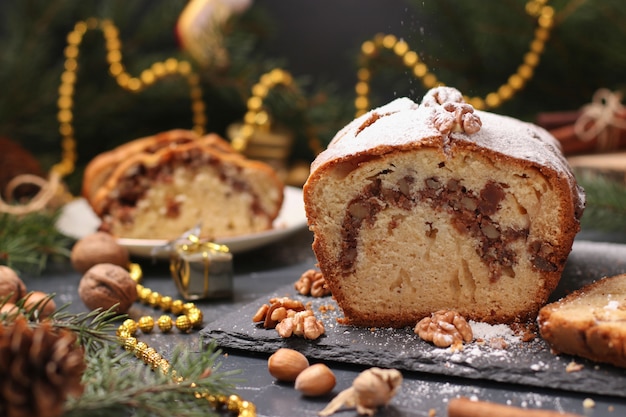 Weihnachtskleiner kuchen mit den Nüssen und kandiert, bedeckt mit dem Puderzucker gelegen auf dem Weihnachten