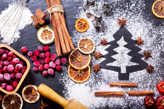 Weihnachtskochtannenbaum aus Mehl auf einem dunklen Tisch Zutaten zum Backen