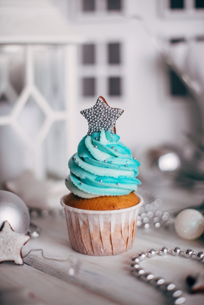 Weihnachtsköstliche kleine Kuchen verziert mit einem silbernen Stern.