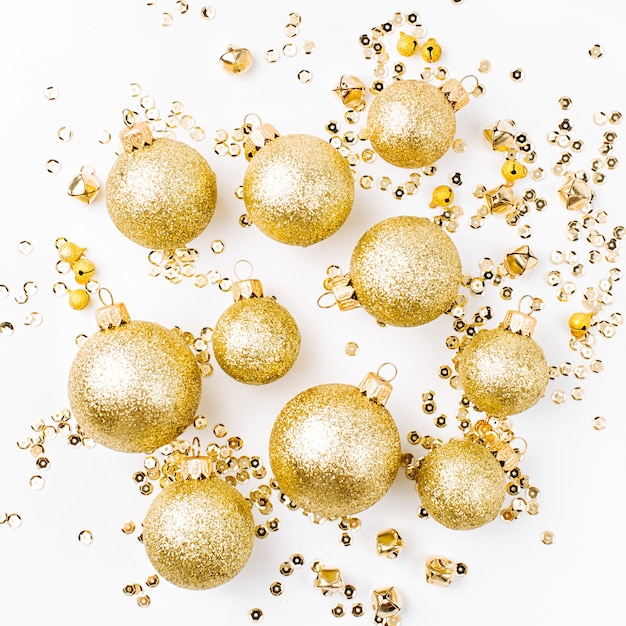 Weihnachtskomposition aus goldenen Weihnachtskugeln auf weißem Hintergrund. Flache Lage, Ansicht von oben