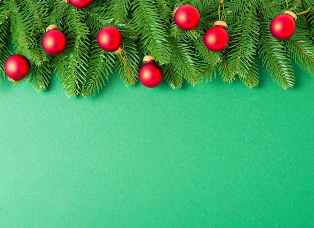 Weihnachtskomposition aus grünen Tannenzweigen mit roten Ballen