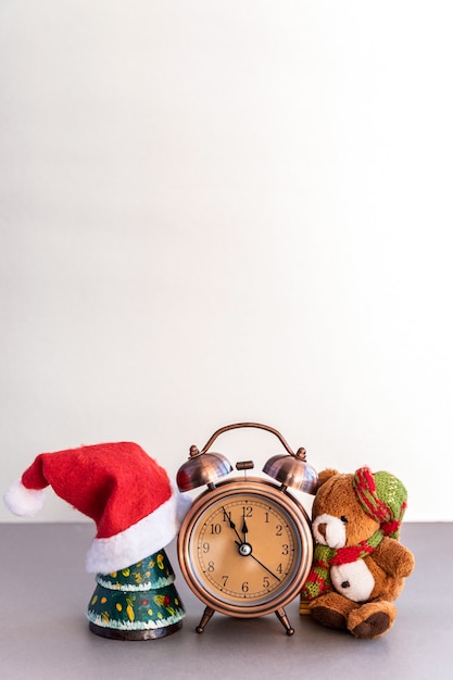 Weihnachtskomposition aus Teddybär und Wecker auf dem Tisch