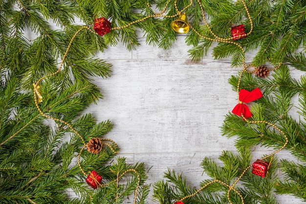 Weihnachtskomposition Christbaumschmuck Tannenzweige auf weißem Holzhintergrund Flacher Draufsichtkopierraum
