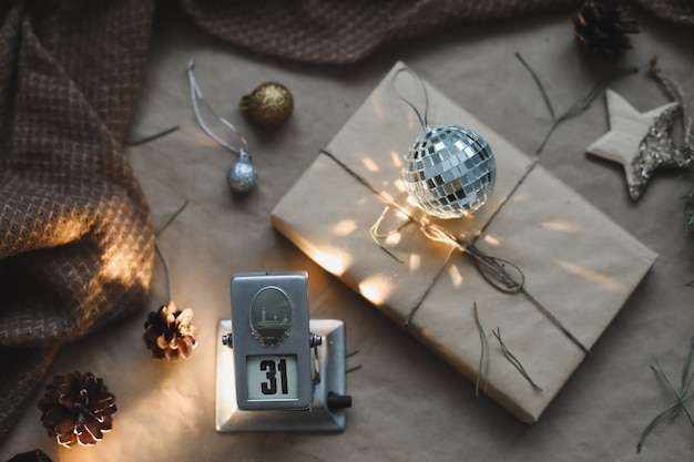 Weihnachtskomposition. Geschenk, Tannenzweige, Bälle auf Kraftpapierhintergrund. Weihnachten, Winter, Neujahrskonzept. Flache Lage, Ansicht von oben, Kopienraum.