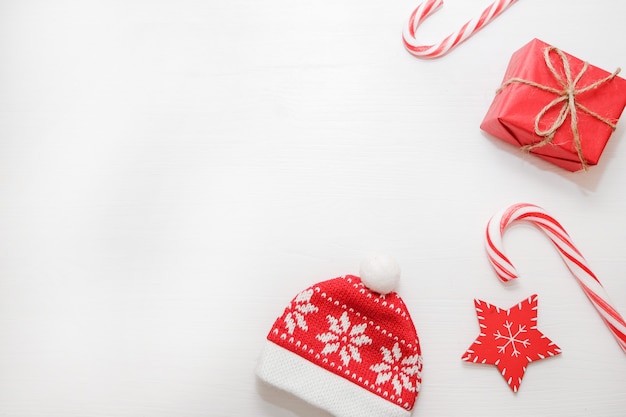 Weihnachtskomposition. Geschenke, Tannenzapfen, rote Dekorationen auf weißem Hintergrund.