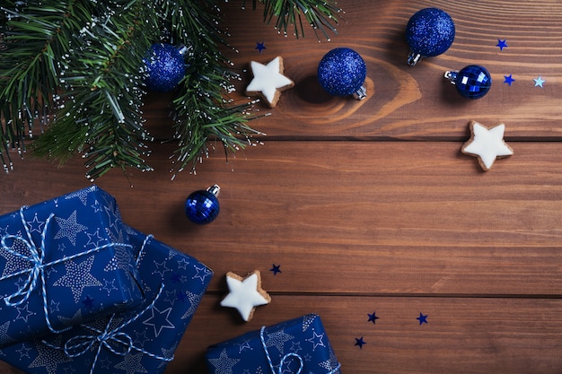Weihnachtskomposition. Geschenke, Tannenzweige, blaue Verzierungen auf Holz. Weihnachts-, Winter-, Neujahrsfeiertagskonzept. Flache Lage, Draufsicht, Kopierraum