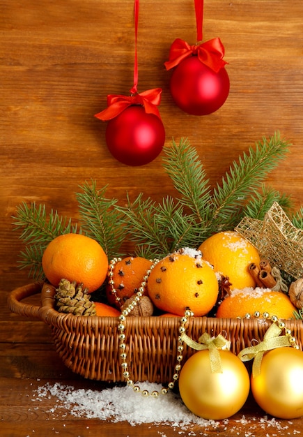 Weihnachtskomposition im Korb mit Orangen und Tannenbaum, auf hölzernem Hintergrund