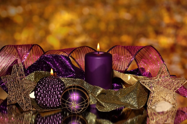 Weihnachtskomposition mit Kerzen und Dekorationen in lila und goldenen Farben