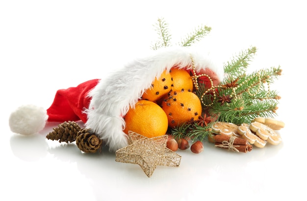 Weihnachtskomposition mit Orangen und Tannenbaum im Weihnachtsmann-Hut isoliert