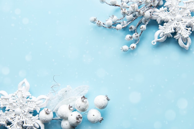 Weihnachtskomposition mit Rahmen aus weißer Dekoration auf pastellblauer Oberfläche