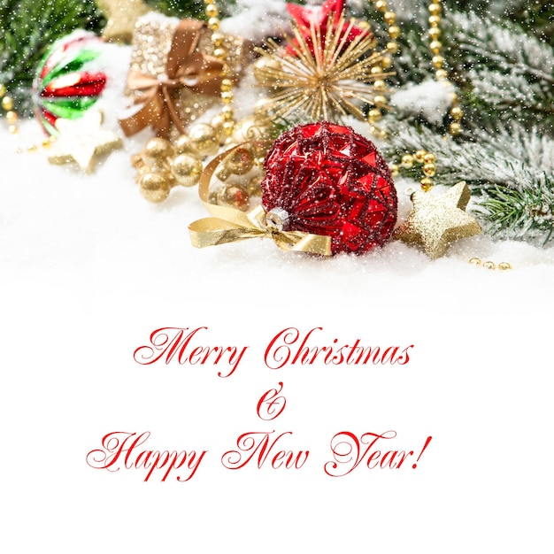 Weihnachtskomposition mit roten Kugeln und goldener Dekoration mit fallendem Schneeeffekt. Kartenkonzept mit Beispieltext Frohe Weihnachten und ein glückliches neues Jahr