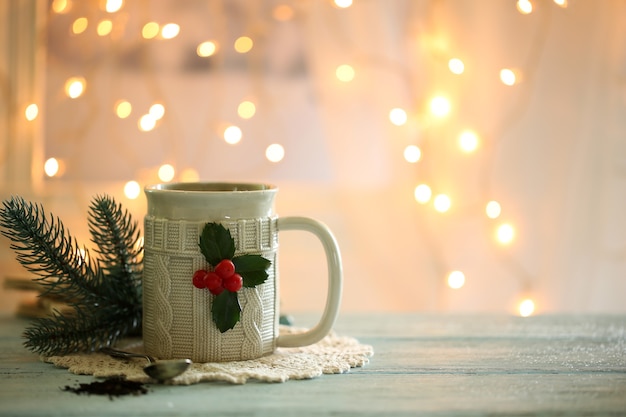 Weihnachtskomposition mit Tasse heißem Getränk, auf Holztisch