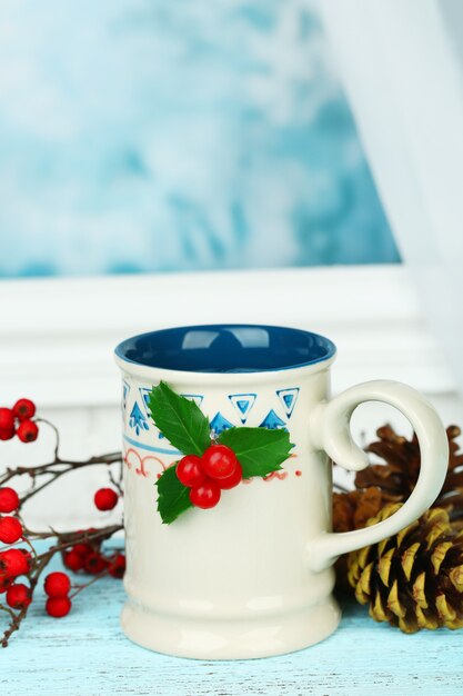 Weihnachtskomposition mit Tasse heißem Getränk, auf Holztisch
