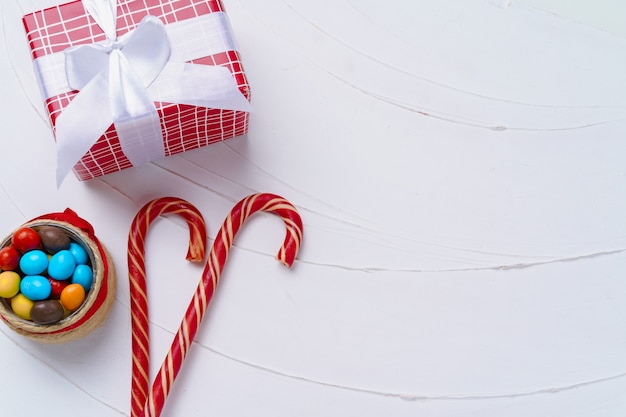 Weihnachtskomposition mit Zuckerstangen auf weißem Holzbrett, Kopienraum