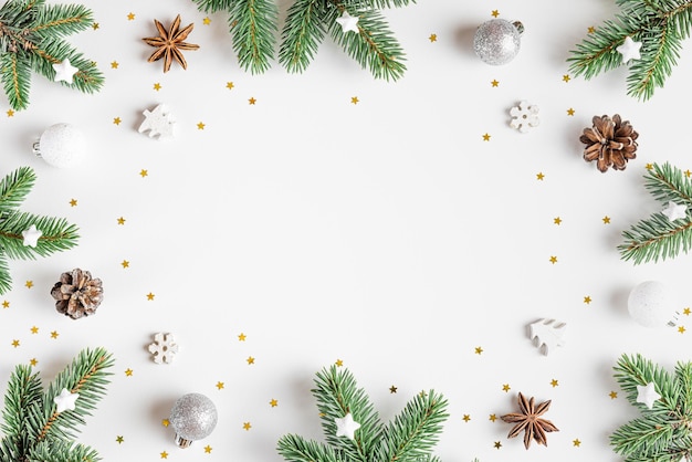 Weihnachtskomposition Rahmen aus Tannenbaum festliche Silberschmuck auf weißem Hintergrund Flaches Lay Minimales Layout