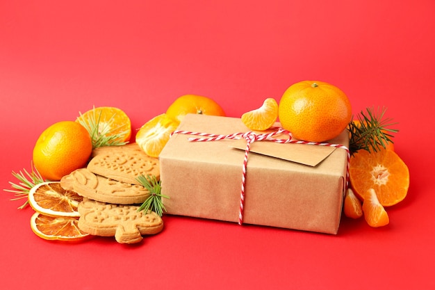 Weihnachtskonzept mit Mandarinen auf rotem Grund