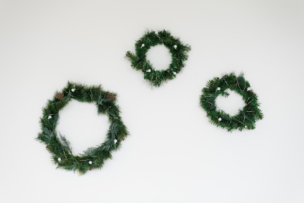 Weihnachtskränze mit Tannenbaum auf weißer Wandwand