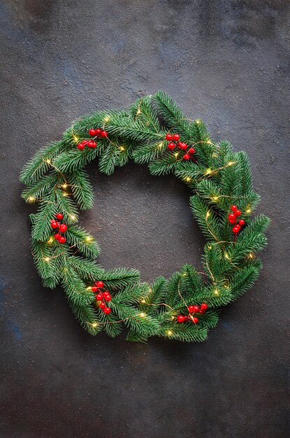 Foto weihnachtskranz aus tannenzweigen mit lichtern und dekorationen