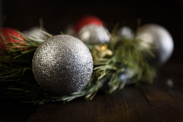 Weihnachtskranz aus Tannenzweigen mit Weihnachtsschmuck, Tannenzapfen und Geschenken auf braunem Hintergrund