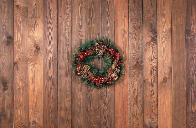 Weihnachtskranz mit grünem Lametta auf Holzwand