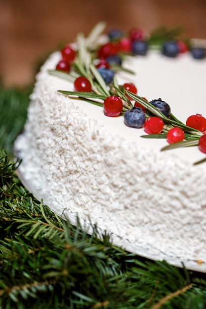 Foto weihnachtskuchen mit beeren auf dem hintergrund der tannenzweige