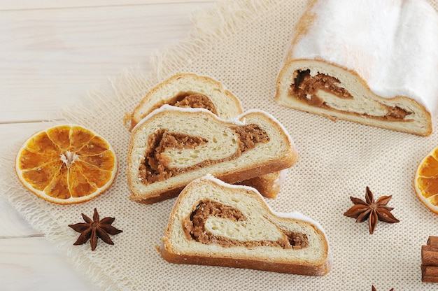 Weihnachtskuchen mit Puderzucker, in Scheiben geschnitten auf der Leinwand