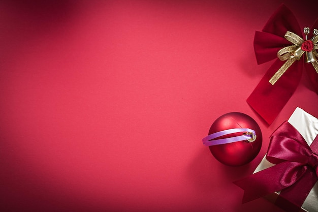 Weihnachtskugel Bogen Geschenkbox auf rotem Hintergrund Urlaub Konzept