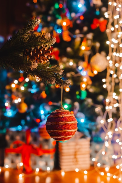 Weihnachtskugel hängt an einem geschmückten Tannenbaum