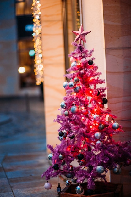 Weihnachtskugel hängt von einem rosa Baum