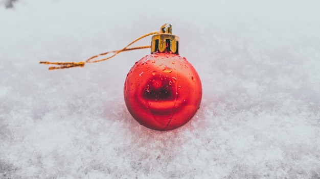 Weihnachtskugel im Schnee einzelne rote Kugel