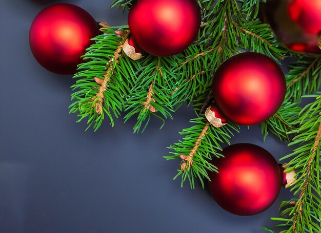 Weihnachtskugeln auf einem Ast eines Baumes auf schwarzem Hintergrund