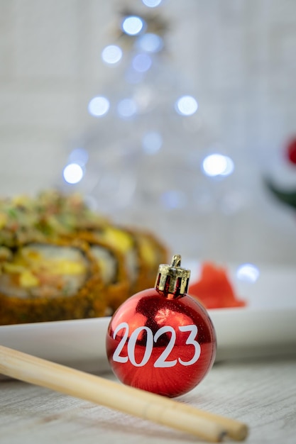 weihnachtskugeln auf einem holztisch und einer sushiplatte