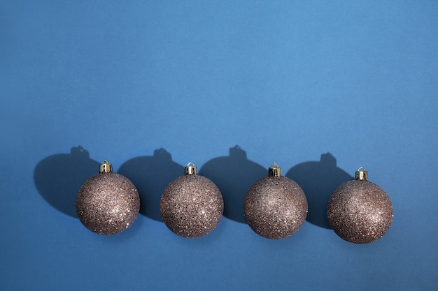 Foto weihnachtskugeln liegen in einer reihe auf einem blauen hintergrund