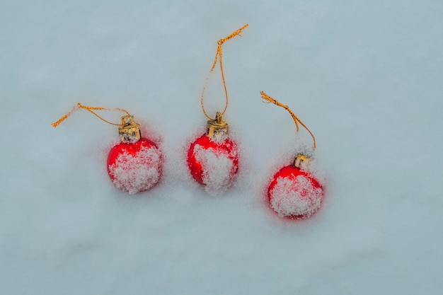 Weihnachtskugeln mit Schnee bedeckt drei rote Kugeln