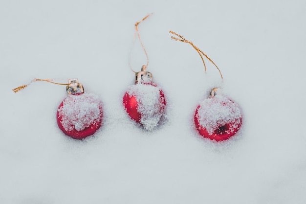 Weihnachtskugeln mit Schnee bedeckt drei rote Kugeln