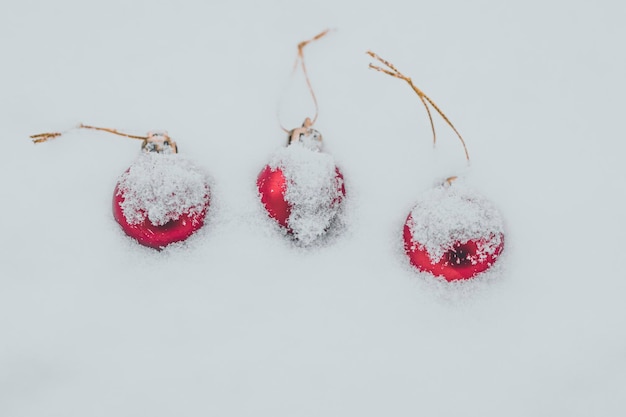 Weihnachtskugeln mit Schnee bedeckt drei rote Kugeln