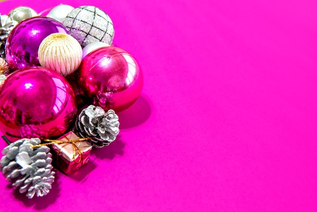 Weihnachtskugeln und Ornamente auf rosa Hintergrund